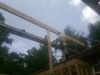 Carpenter setting a ridge beam over a new addition frame — Ice Dam Removal by Roofing Brothers in Maryknoll