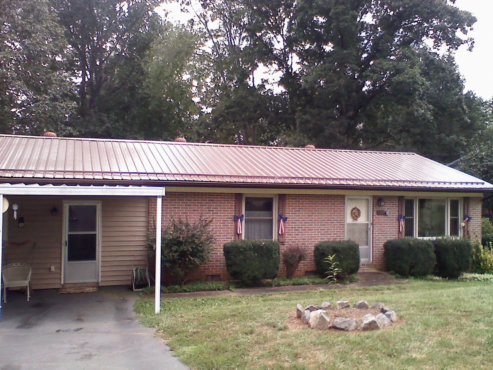 Bronze metal roof and carport on a brick ranch home — Roof Repair work by our crew in Maryknoll